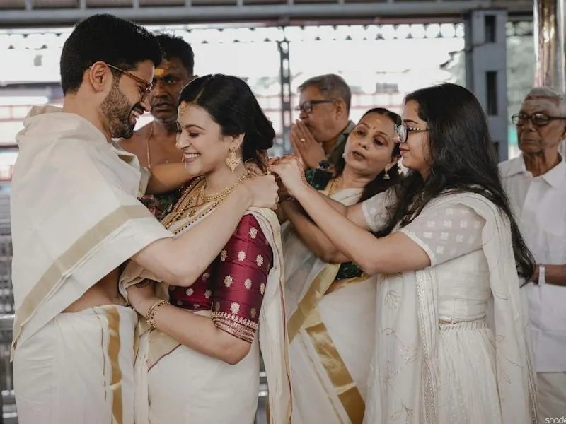 South Indian wedding family in traditional white and gold kasavu attire
